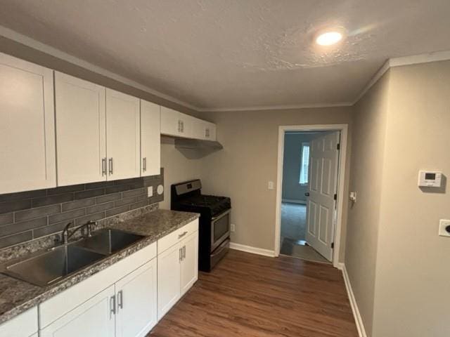 kitchen featuring stainless steel range with gas cooktop, dark hardwood / wood-style floors, white cabinetry, sink, and decorative backsplash