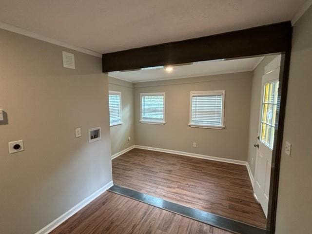 empty room with beam ceiling, ornamental molding, and dark hardwood / wood-style floors