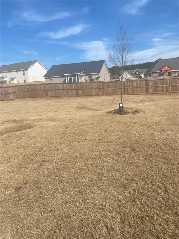 view of yard featuring a fenced backyard and a residential view