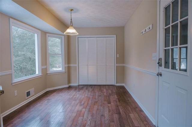 110 Fox Meadow Dr, Covington, GA 30016 - unfurnished dining area featuring dark wood-style floors, baseboards, and a textured ceiling