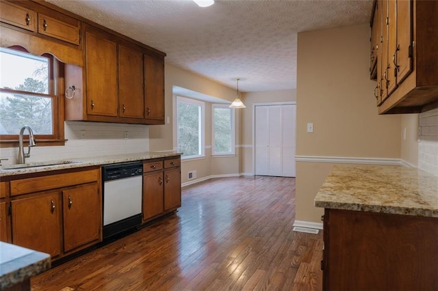 110 Fox Meadow Dr, Covington, GA 30016 - kitchen featuring white dishwasher, a sink, brown cabinetry, light countertops, and a textured ceiling