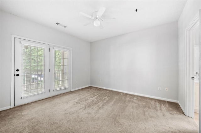 spare room featuring visible vents, baseboards, and light colored carpet