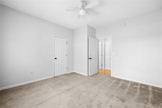 unfurnished bedroom featuring carpet floors, baseboards, and a ceiling fan