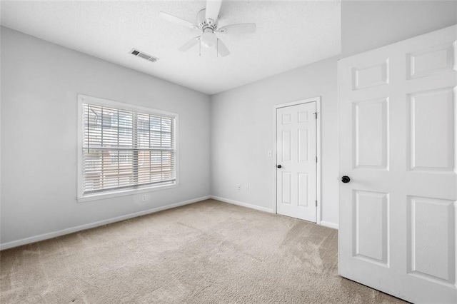 unfurnished bedroom with carpet floors, baseboards, and visible vents