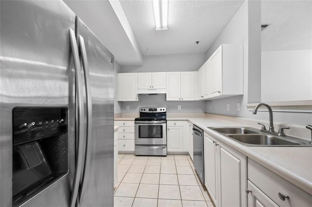 kitchen featuring light countertops, a textured ceiling, under cabinet range hood, a sink, and appliances with stainless steel finishes