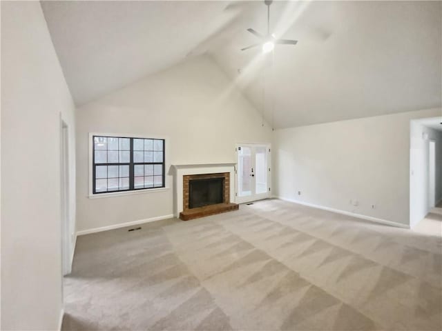 unfurnished living room with high vaulted ceiling, a fireplace, light colored carpet, and ceiling fan