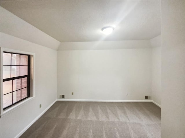 unfurnished room with carpet and lofted ceiling