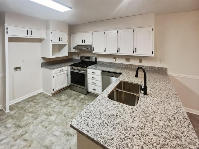 kitchen with stainless steel appliances, sink, white cabinets, and light stone counters