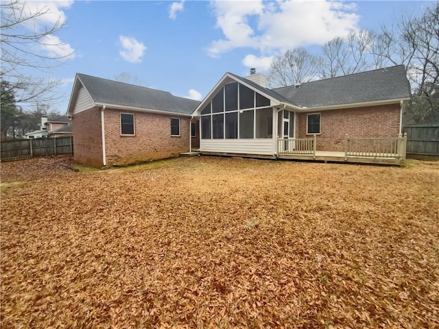 rear view of property with a deck and a sunroom