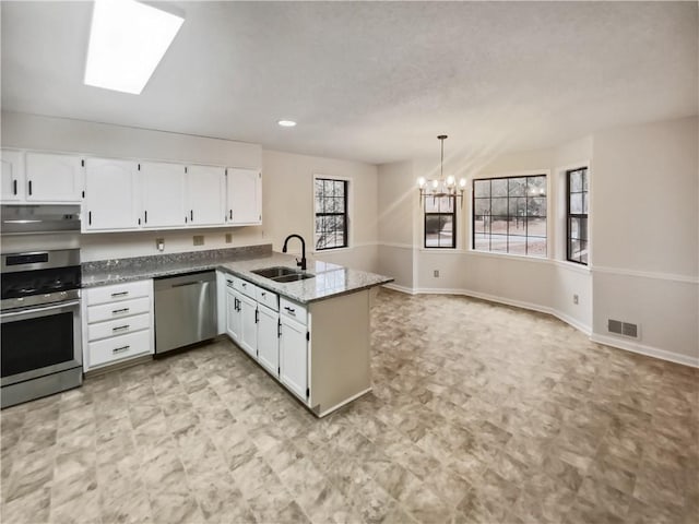 kitchen featuring sink, white cabinetry, a chandelier, appliances with stainless steel finishes, and kitchen peninsula