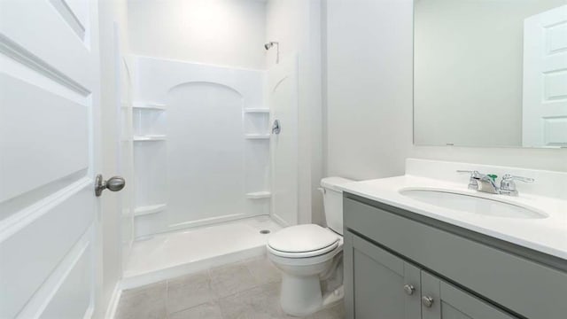 bathroom with vanity, tile patterned floors, toilet, and walk in shower