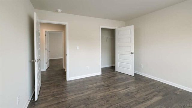 unfurnished bedroom featuring dark hardwood / wood-style flooring and a closet