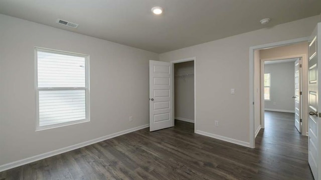 unfurnished bedroom featuring dark hardwood / wood-style flooring and a closet