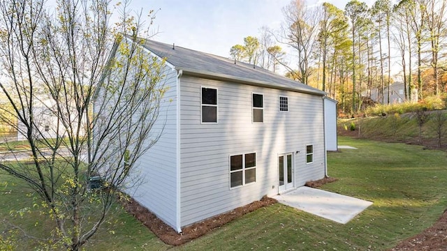 rear view of property with a lawn and a patio