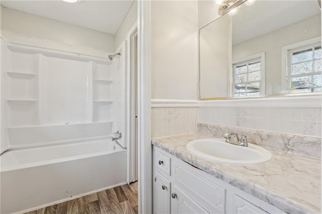 bathroom with shower / washtub combination, tasteful backsplash, vanity, and wood finished floors