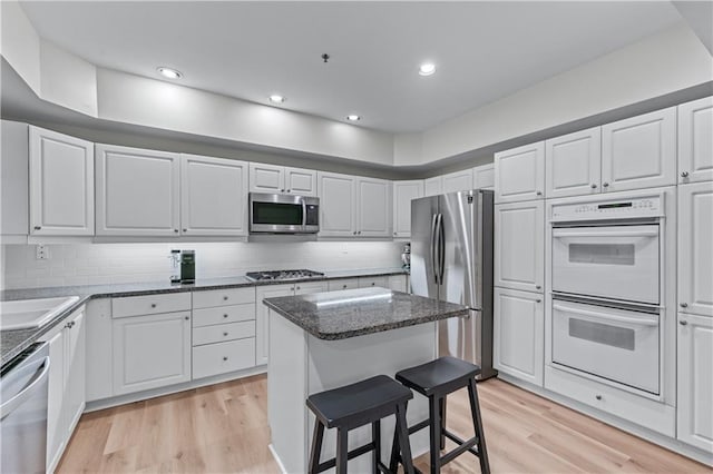 3636 Habersham Rd NW Unit 2101, Atlanta, GA 30305 - kitchen featuring stainless steel appliances, light wood-type flooring, white cabinets, a kitchen island, and recessed lighting
