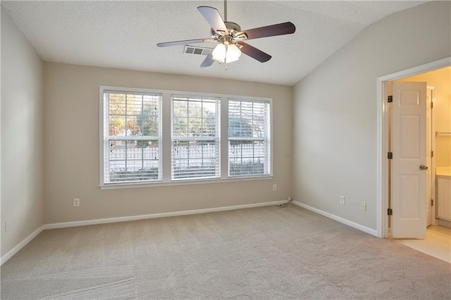 unfurnished room featuring light carpet, lofted ceiling, a textured ceiling, and ceiling fan