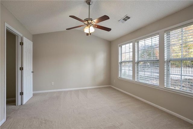 carpeted spare room featuring ceiling fan, a textured ceiling, and vaulted ceiling