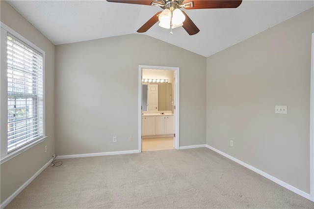 unfurnished room featuring ceiling fan, lofted ceiling, and light colored carpet