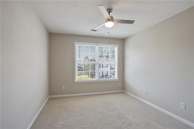 carpeted spare room featuring ceiling fan and a textured ceiling