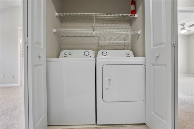 clothes washing area featuring light carpet, washing machine and dryer, and ceiling fan