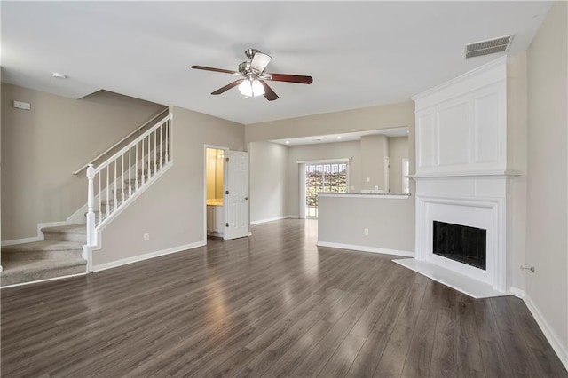 unfurnished living room with ceiling fan, dark hardwood / wood-style flooring, and a fireplace