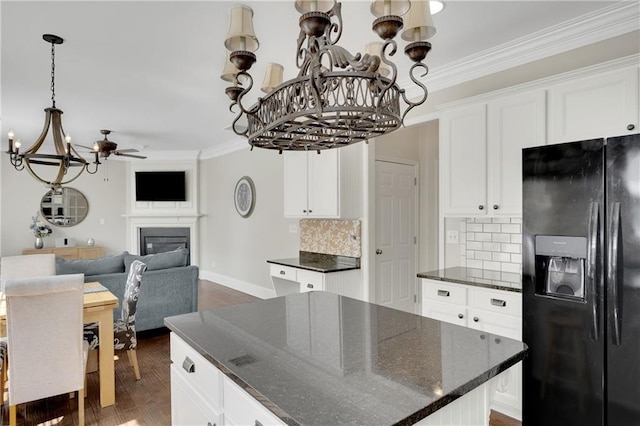 kitchen with ornamental molding, a glass covered fireplace, dark wood-style floors, open floor plan, and black refrigerator with ice dispenser