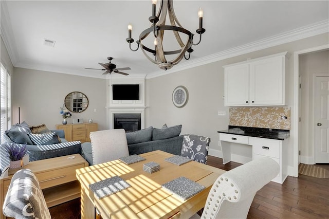 dining area with visible vents, crown molding, baseboards, a fireplace, and dark wood-style floors