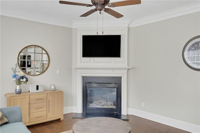 living area featuring crown molding, baseboards, a fireplace, a ceiling fan, and dark wood-style flooring