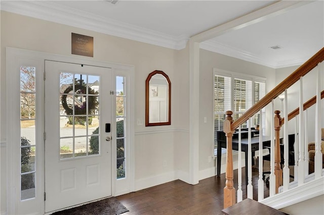 foyer entrance featuring visible vents, baseboards, dark wood finished floors, ornamental molding, and stairs