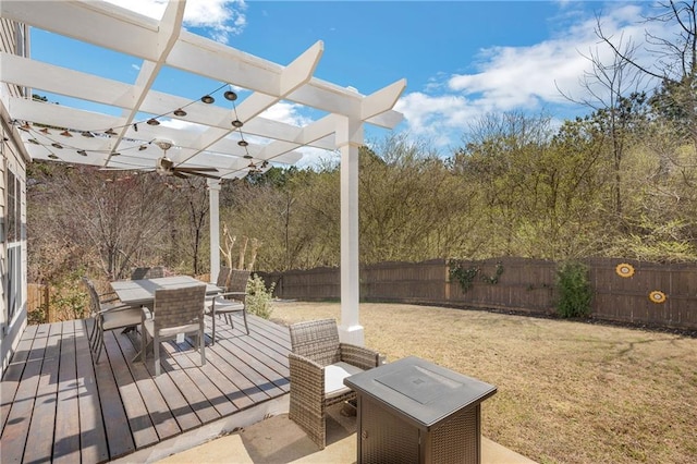 wooden deck featuring a fenced backyard, a lawn, outdoor dining space, and a pergola