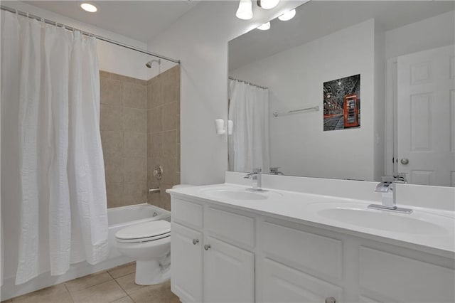 bathroom featuring double vanity, shower / bath combo, a sink, tile patterned floors, and toilet