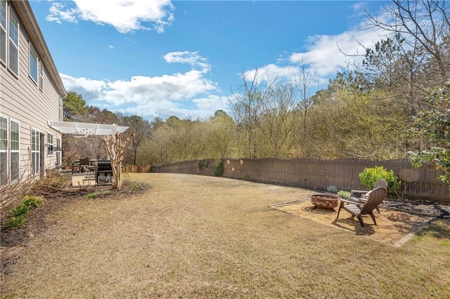 view of yard with a patio area, a fenced backyard, and an outdoor fire pit