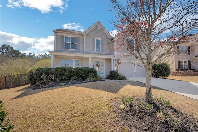 traditional-style house with a front yard, an attached garage, fence, and driveway