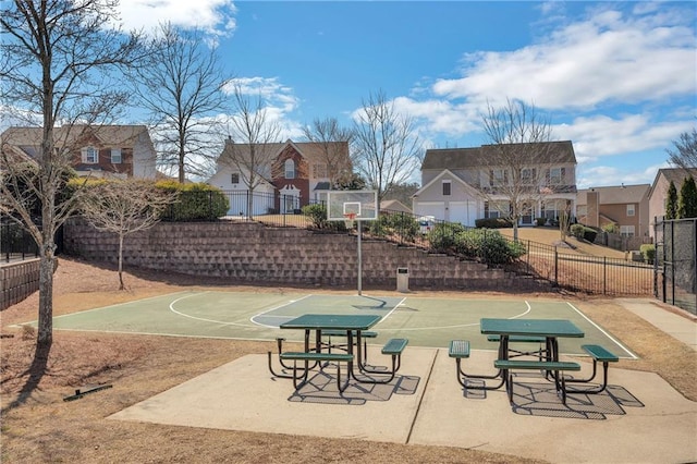 view of basketball court with community basketball court, fence, and a residential view