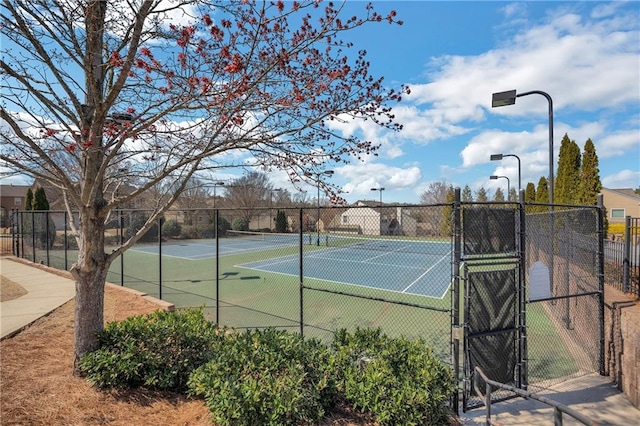 view of sport court with a gate and fence