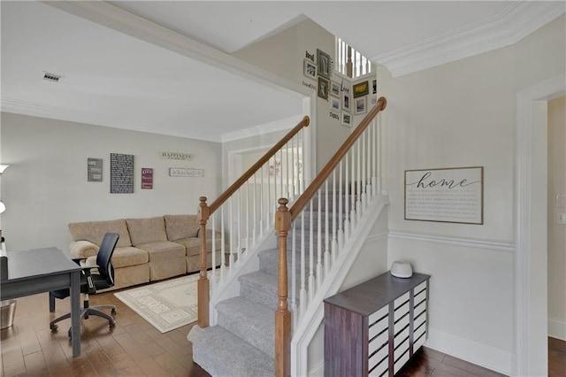 staircase with baseboards, wood finished floors, visible vents, and ornamental molding