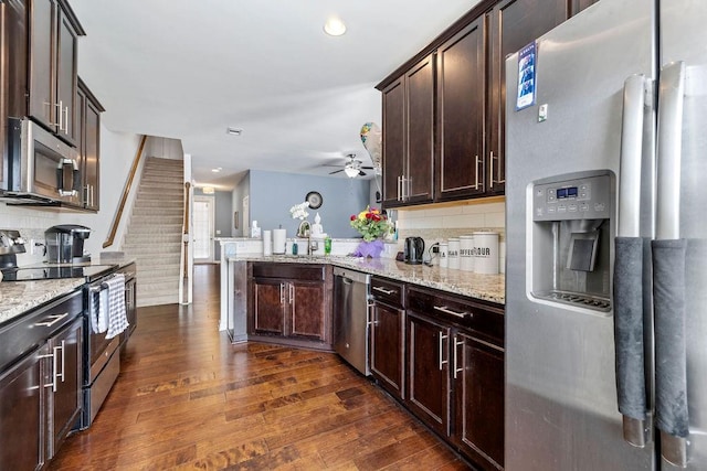 kitchen with stainless steel appliances, dark brown cabinets, tasteful backsplash, dark hardwood / wood-style flooring, and ceiling fan