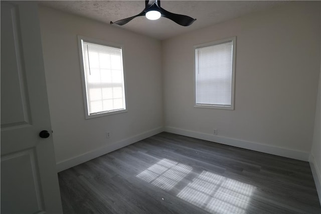 empty room featuring a textured ceiling, ceiling fan, and dark wood-type flooring