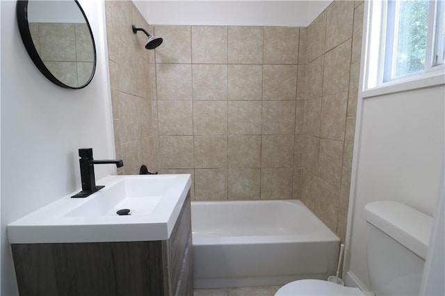 full bathroom featuring tiled shower / bath, vanity, and toilet