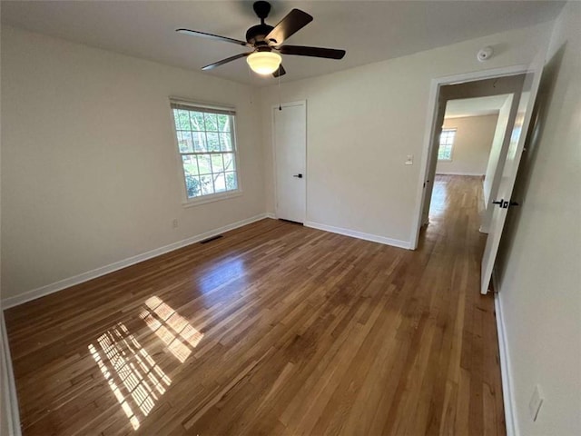 779 Casplan St SW, Atlanta, GA 30310 - unfurnished bedroom with wood finished floors, visible vents, baseboards, and multiple windows