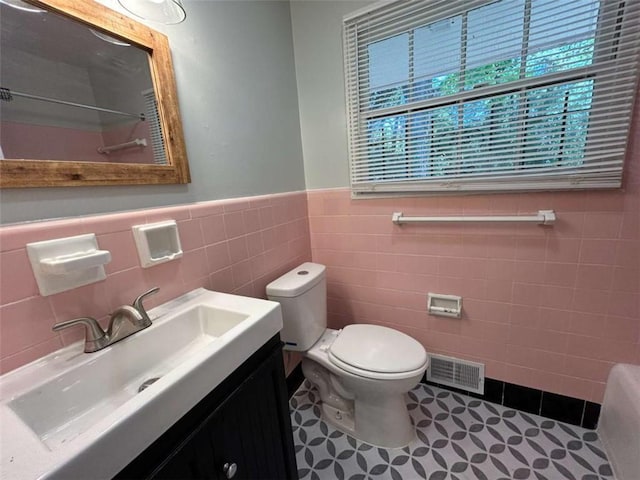 779 Casplan St SW, Atlanta, GA 30310 - bathroom featuring a wainscoted wall, visible vents, toilet, vanity, and tile walls