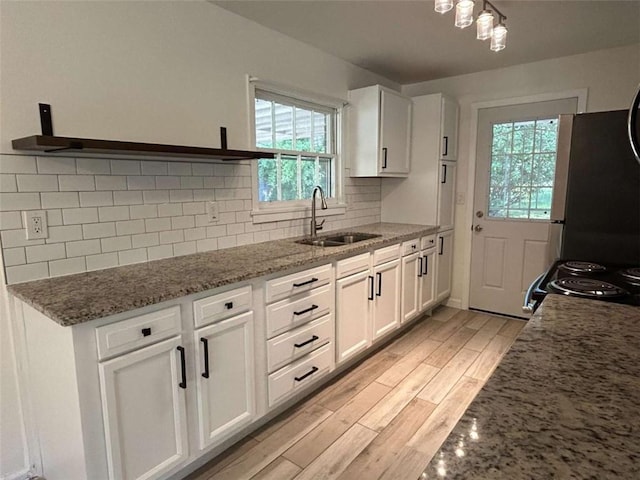 779 Casplan St SW, Atlanta, GA 30310 - kitchen featuring light wood-style flooring, a healthy amount of sunlight, white cabinetry, and a sink