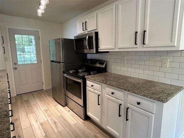 779 Casplan St SW, Atlanta, GA 30310 - kitchen featuring white cabinets, backsplash, light wood-style floors, light stone countertops, and appliances with stainless steel finishes