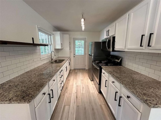 779 Casplan St SW, Atlanta, GA 30310 - kitchen featuring light wood finished floors, stainless steel appliances, backsplash, a sink, and white cabinetry
