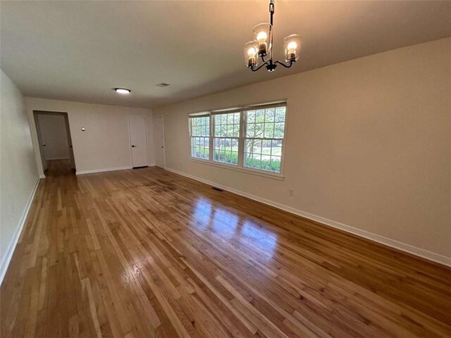 779 Casplan St SW, Atlanta, GA 30310 - unfurnished room featuring baseboards, a notable chandelier, wood finished floors, and visible vents