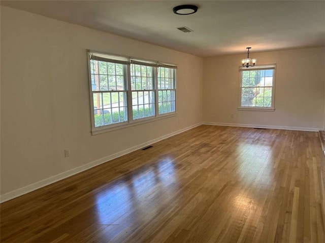 779 Casplan St SW, Atlanta, GA 30310 - spare room with baseboards, dark wood-type flooring, visible vents, and a notable chandelier