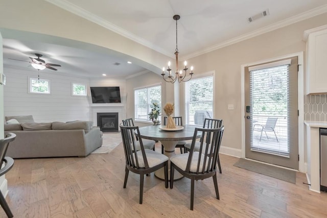 4230 Old Cherokee St, Acworth, GA 30101 - dining room featuring a glass covered fireplace, light wood-style floors, a chandelier, crown molding, and arched walkways