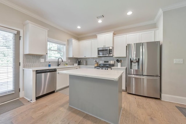 4230 Old Cherokee St, Acworth, GA 30101 - kitchen featuring appliances with stainless steel finishes, tasteful backsplash, white cabinetry, light wood-type flooring, and ornamental molding