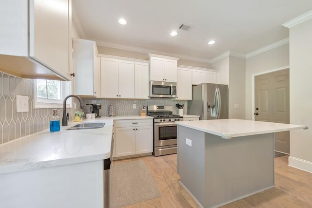 4230 Old Cherokee St, Acworth, GA 30101 - kitchen featuring appliances with stainless steel finishes, a center island, backsplash, white cabinetry, and ornamental molding